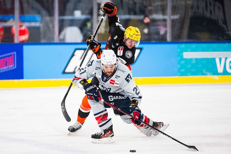 Julian Napravnik von den Lwen Frankfurt und Kris Bennett von den Adler Mannheim im Zweikampf.