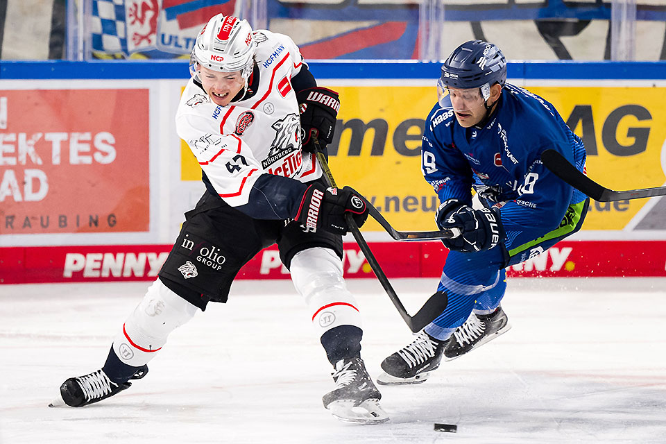 Owen Headrick von den Nürnberg Ice Tigers schießt den Puck vor Tim Brunnhuber von den Straubing Tigers Owen Headrick von den Nürnberg Ice Tigers schießt den Puck vor Tim Brunnhuber von den Straubing Tigers